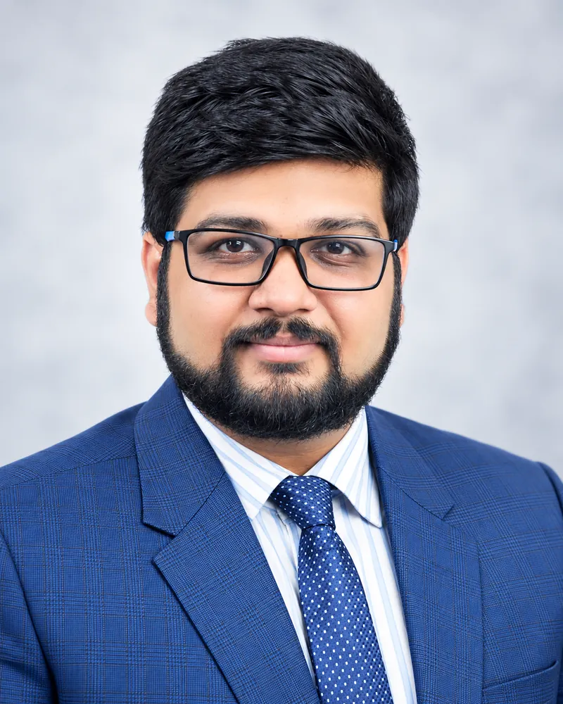 Formal portrait of Angad Kulkarni in a blue suit and patterned tie