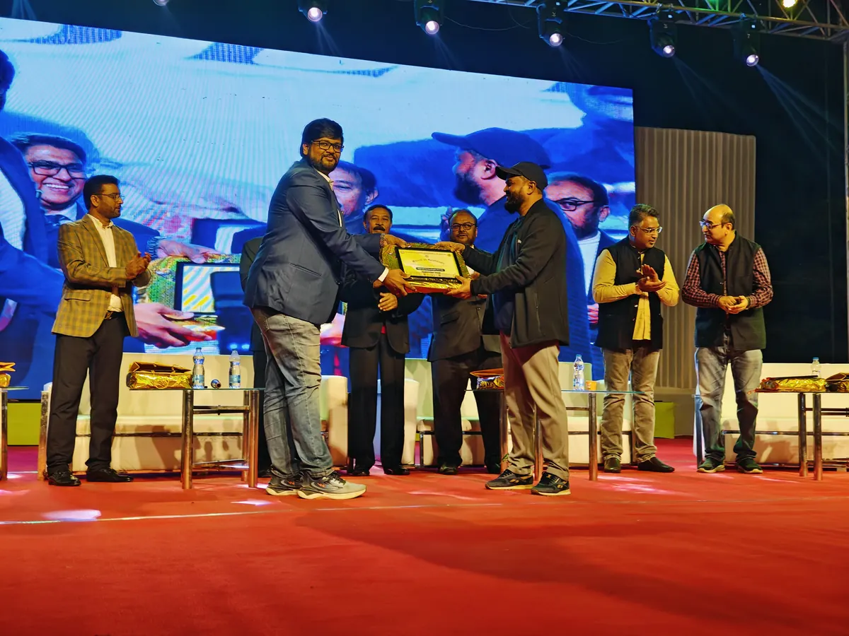 Angad Kulkarni receiving a memento on stage at an industry event